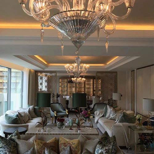 Formal lounge with layered and chandelier lighting